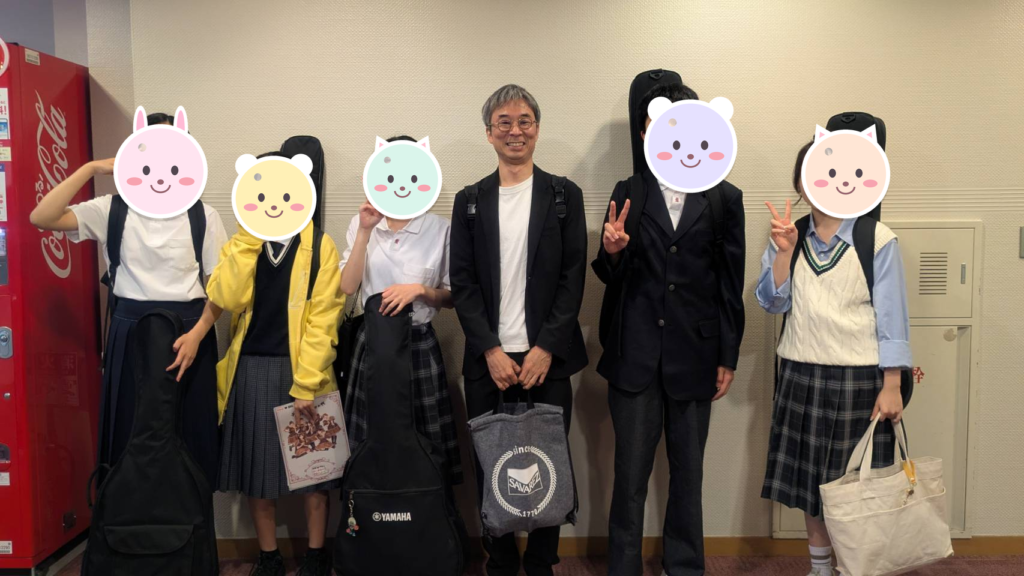 ギターケースを持って並ぶ6人の集合写真
